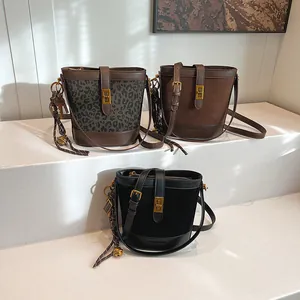 Trois sacs seaux en imprimé léopard, marron et noir avec ferrures dorées et breloques