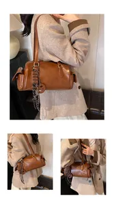 Vue détaillée d'un sac cylindrique marron vintage avec poches et pendentif chocolat