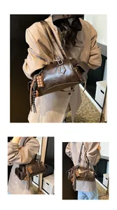 Détail du sac cylindre en cuir marron foncé avec poches et pendentif chocolaté