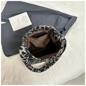 Close-up of leopard plush tote interior with metal zipper pocket and magnetic snap button