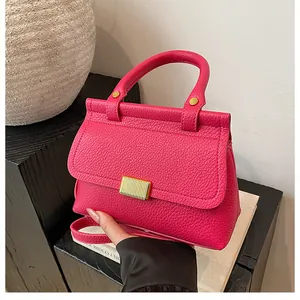 Vue détaillée du sac à main rose fuchsia en cuir grainé avec boucle dorée et poignée