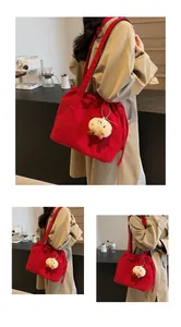 Detail of red corduroy tote bag with brown plush pendant for school and commuting
