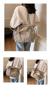 Detail view of grey corduroy tote bag featuring drawstring closure and front pocket