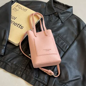Mini sac cabas rose en cuir grainé avec bandoulière sur fond d'objets vintage élégants