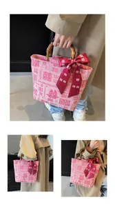 Detail of pink canvas tote with bamboo handles, silk bow, and Chinese wedding pattern