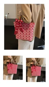 Detail of red wedding canvas tote bag with bamboo handles and festive silk bow decor