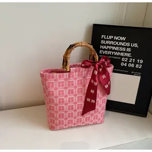 Close-up of pink canvas tote bag featuring double happiness patterns and bamboo handle