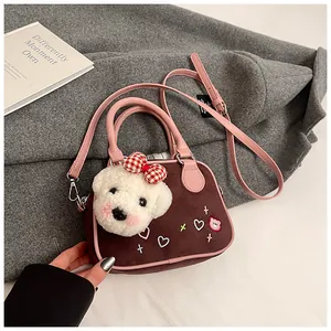 Détail du mini sac à main dépoli avec charm de chien en peluche et bordure en similicuir rose