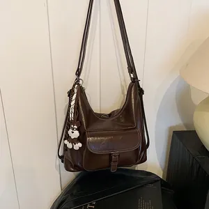 Braune Vintage-Ledertasche mit glänzendem Finish, Plüschhund-Anhänger und Halstuch