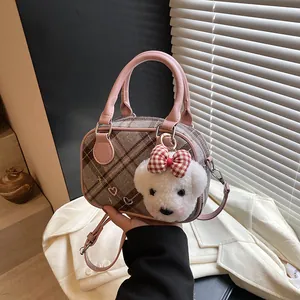Sac Boston à carreaux marron avec poignées en cuir rose et pendentif ours en peluche