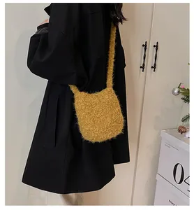 Détail d'un sac à bandoulière en peluche jaune gingembre sur un manteau d'hiver