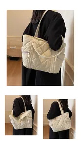 Macro detail of quilted cream tote bag showing puffer texture and zip side pocket