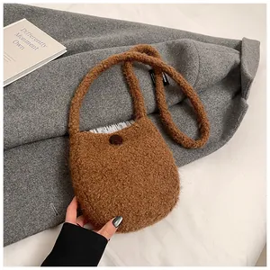 Détail de la sacoche en peluche marron montrant la texture douce et le bouton de fermeture