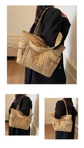 Detail view of beige quilted nylon tote bag showing side zipper pocket and large capacity