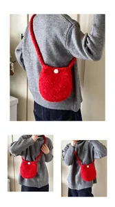 Détail du sac seau bandoulière rouge en peluche douce avec pompon blanc décoratif