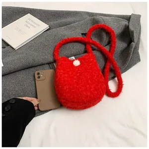 Détail du mini sac seau en peluche rouge montrant la texture douce et le pompon