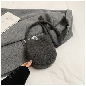 Détail de la texture en peluche gris foncé sur un mini sac seau élégant et moderne