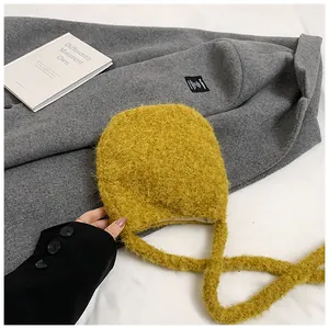 Détail du sac à bandoulière en fausse fourrure jaune doux avec texture pelucheuse et sangle