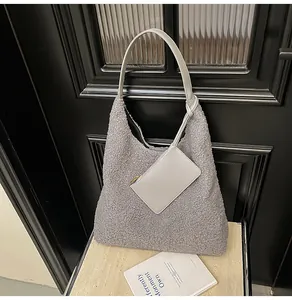 Dettaglio della texture della borsa tote grigia in peluche e bustina coordinata con zip