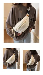 Close-up of white quilted nylon chest bag featuring adjustable strap and embroidery details