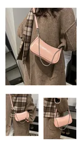 Détail du sac croissant en cuir ciré rose avec chaîne argentée et bandoulière