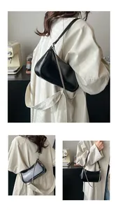 Gros plan d'un sac porté épaule noir en cuir ciré vintage avec chaîne argentée fine