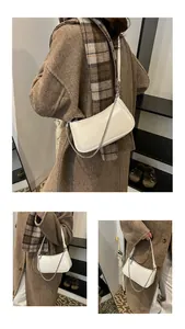 Détail du sac baguette en similicuir blanc cassé avec chaîne argentée et bandoulière réglable