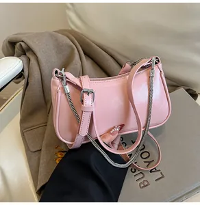 Détail du sac en cuir rose effet huilé avec bandoulière chaîne argentée et texture plissée