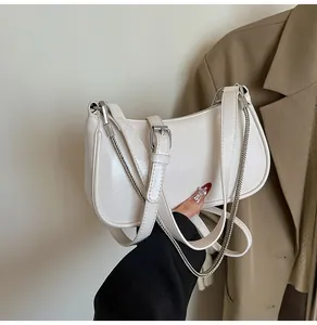 Détail du sac demi-lune blanc en cuir ciré avec une chaîne argentée et bandoulière
