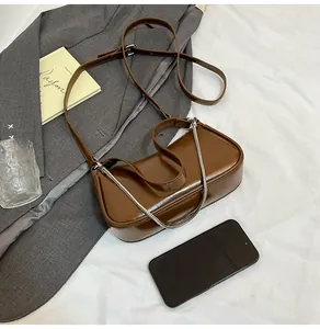 Détail du sac à bandoulière en cuir ciré caramel avec chaîne argentée et fini brillant