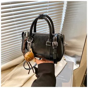 Détail du sac Boston en cuir ciré noir avec pendentif baseball et bandoulière amovible