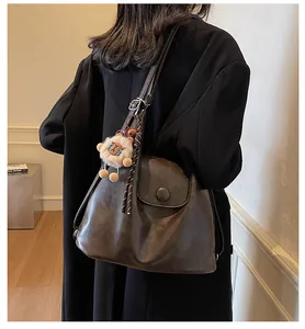 Close-up of retro large-capacity tote bag in dark brown with lion plush pendant