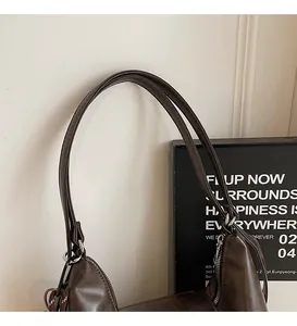 Detail view of the soft double handles and smooth oil edge of this dark brown tote bag