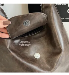 Macro view of the invisible magnetic buckle on this retro dark brown tote bag