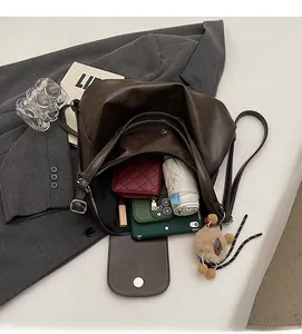 Interior view of brown leather tote showing storage for phone, umbrella, and wallet
