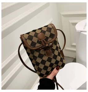 Brown checkered crossbody phone bag with leather trim and horn button closure