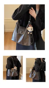 Deep brown tote bag detail with vintage leather texture and cute plush alpaca charm