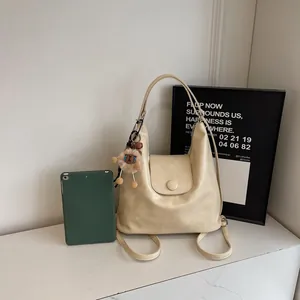 Minimalist beige tote bag with cute bear pendant displayed on a stylish marble table