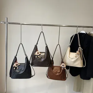 Versatile Hobo tote bags in black, brown, and cream with plush charm accents