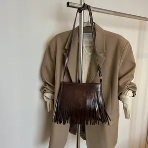 Détail du sac à bandoulière en similicuir marron foncé avec de longues franges élégantes