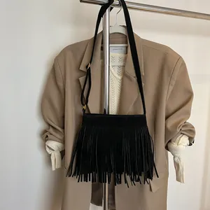 Détail du sac bandoulière bohème noir avec de longues franges denses et aspect daim