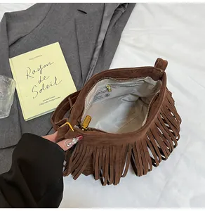 Détail intérieur du sac bohème en daim marron avec franges et finitions dorées