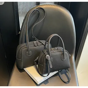 Détails de sacs en cuir noir avec surpiqûres blanches et garnitures métalliques