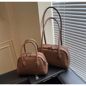 Gros plan de sacs Boston en cuir grainé marron en deux tailles avec gravure enjoy chan