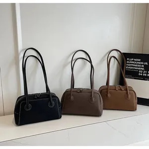 Détail de trois sacs à bandoulière minimalistes avec surpiqûres et de longues anses