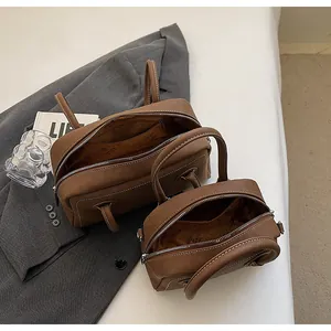 Gros plan sur le cuir marron grainé et l'ensemble de sacs avec surpiqûres blanches