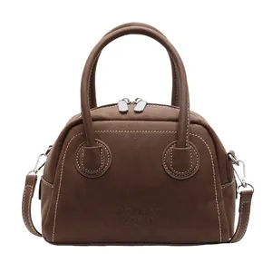 Sac bowling en cuir marron avec coutures contrastées blanches et bandoulière amovible