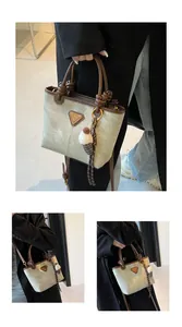 Detail view of mint green handbag with brown handles and plush ice cream pendant charm