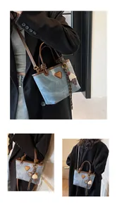 Detail view of denim tote bag with leather trim and decorative ice cream keychain