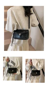 Detail view of black glossy flap bag featuring silver twist lock and woven charm